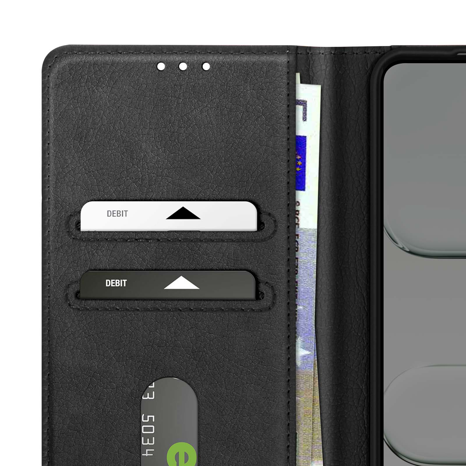 Portafoglio nero con due carte di debito, una banconota da euro e uno smartphone. Portafoglio aperto.