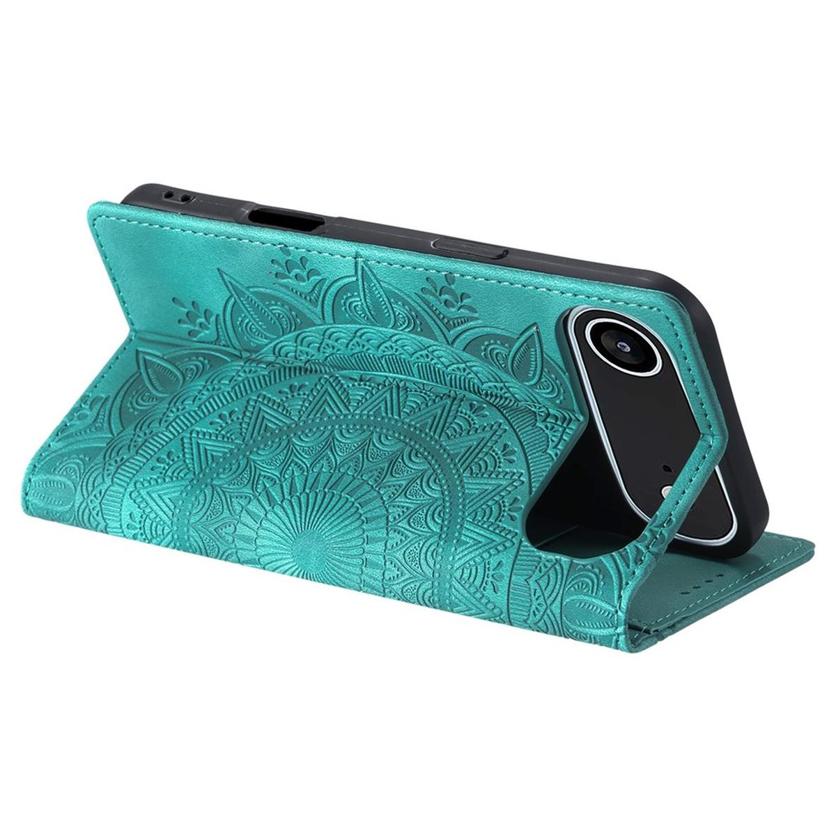 Türkisfarbene Handyhülle mit Mandala-Design, Telefon darin. Die Hülle ist offen und steht aufrecht. Der Hintergrund ist weiß.