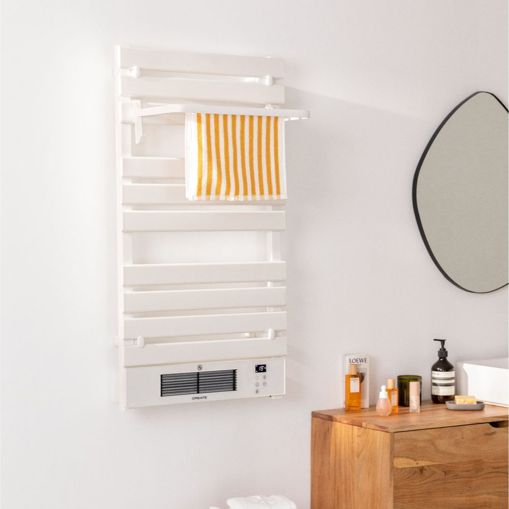 Calentador de baño blanco con toalla. Toalla a rayas en el estante. Gabinete de madera con cosméticos y espejo ovalado. Pared blanca.