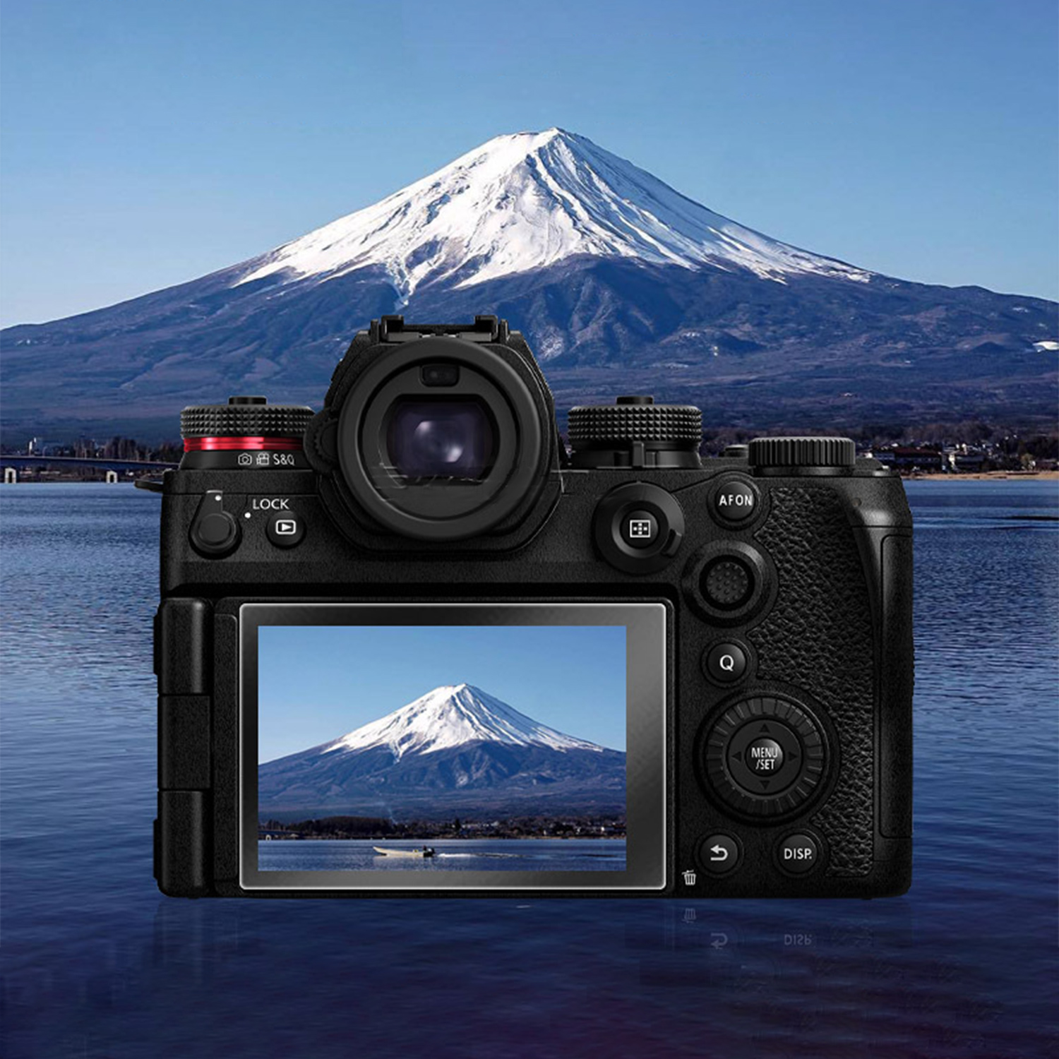 Czarny aparat wyświetla zaśnieżony krajobraz górski. Aparat znajduje się przed tą samą górą i jeziorem.