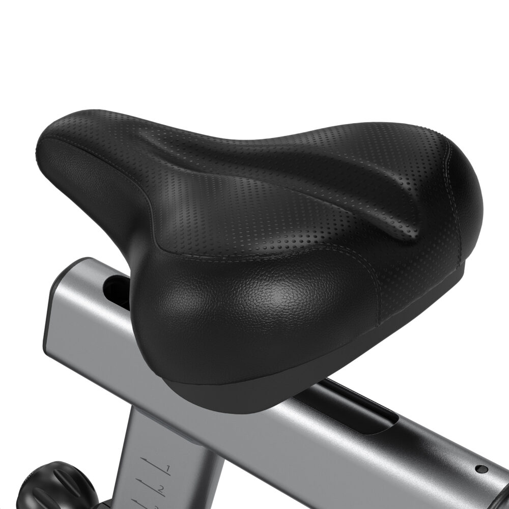 A black, textured bicycle seat is mounted on a silver frame. The seat is curved and padded, with a perforated surface. The frame has numbers.