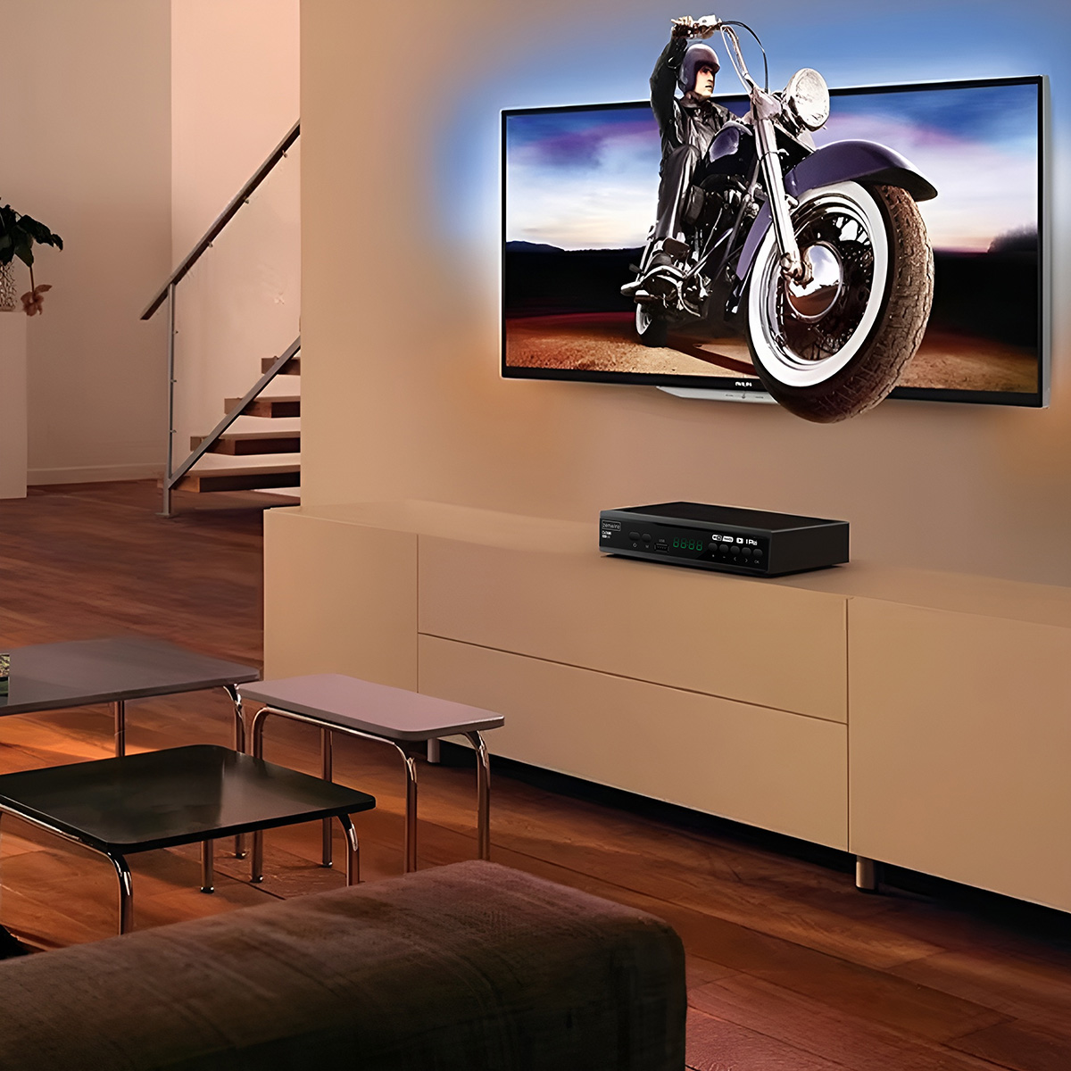 Telewizor wyświetla motocykl. Poniżej znajduje się czarne pudełko. Pokój ma nowoczesne meble i drewniane podłogi.