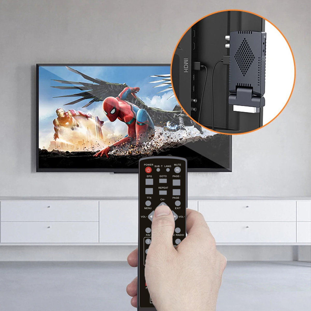 Osoba trzymająca pilota do telewizora. Telewizor pokazuje scenę z Spider-Mana. Urządzenie jest podłączone do telewizora.