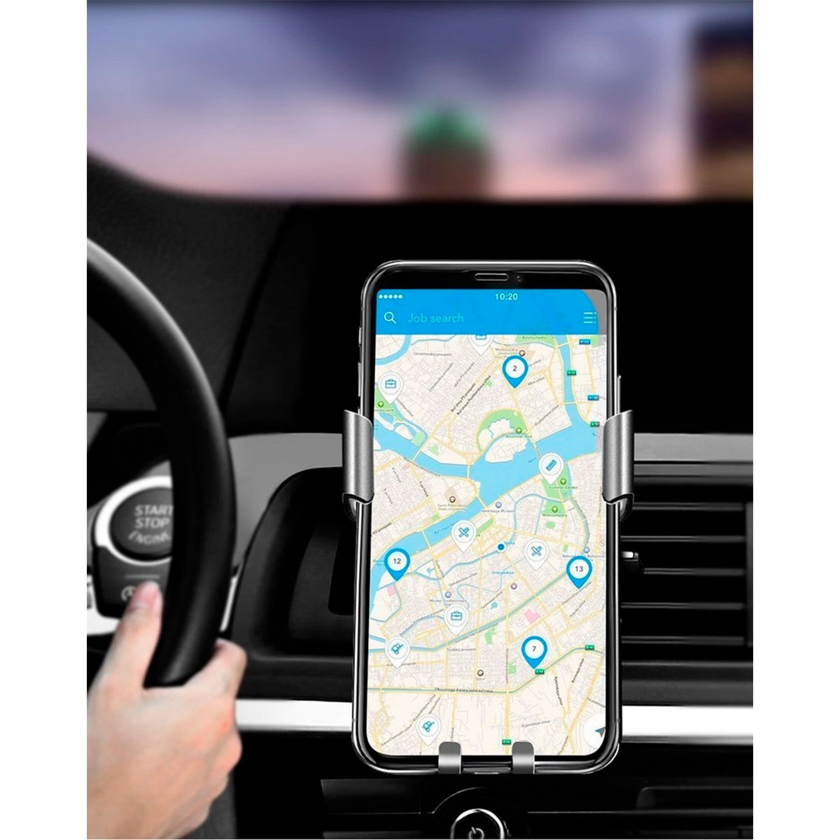 Smartfon wyświetlający mapę ze znacznikami lokalizacji jest zamontowany w samochodzie. Ręka trzyma kierownicę.