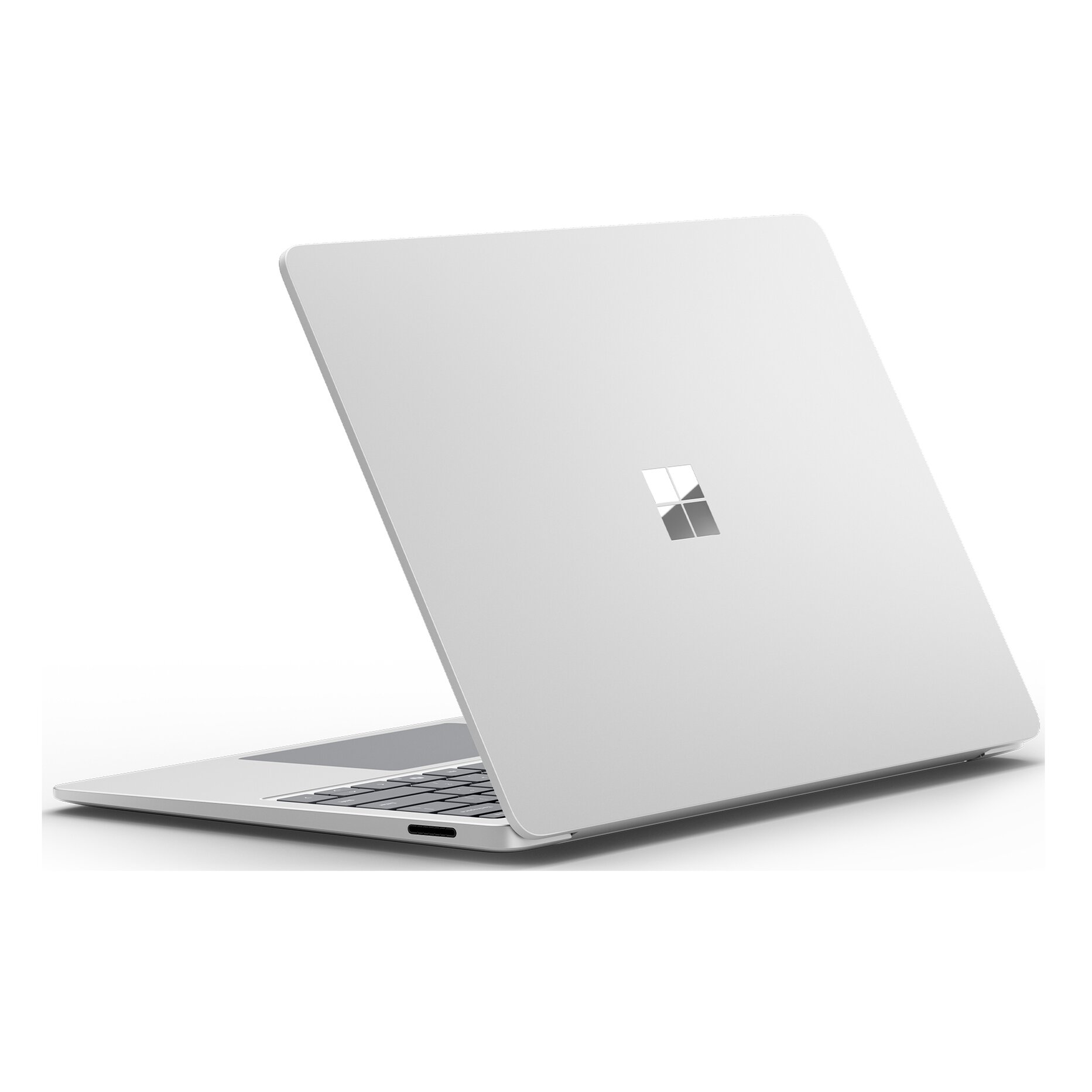 Un laptop argentato è aperto. Il logo Microsoft è sul coperchio. La tastiera è visibile.