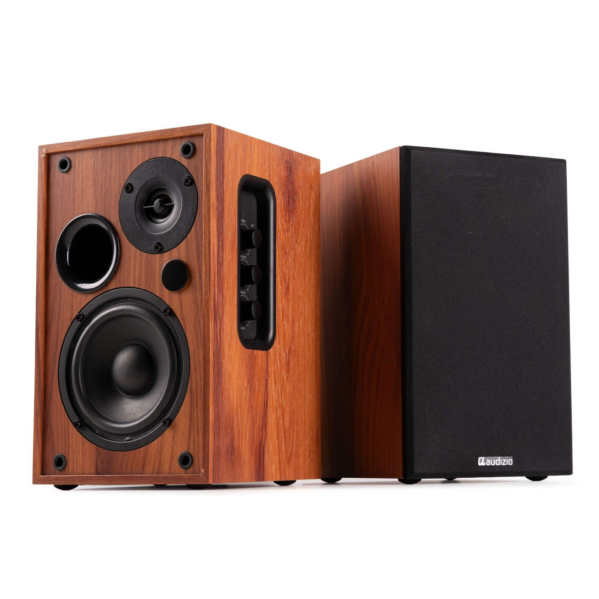 Dos altavoces de madera. Uno tiene múltiples altavoces y controles. El otro es negro. Ambos están sobre un fondo blanco.