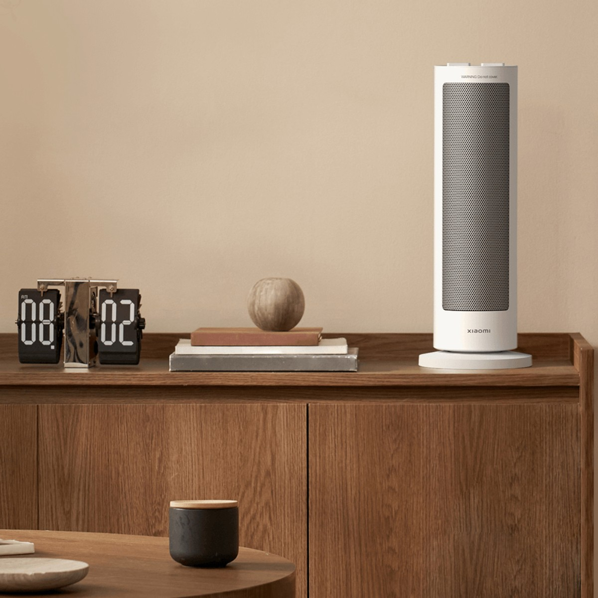 Pokój z drewnianą szafką, zegarem, grzejnikiem, książkami i drewnianą kulą. Filiżanka na stole.