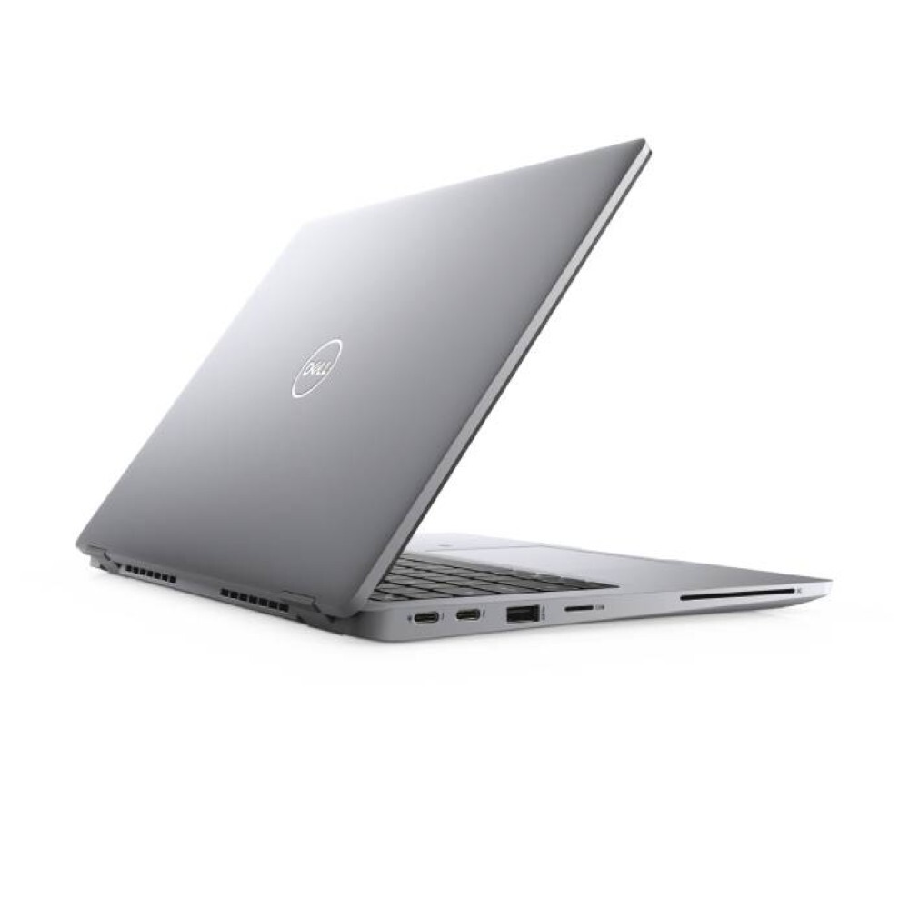 Un portátil Dell gris está ligeramente abierto sobre un fondo blanco. El logotipo de Dell es visible en la tapa. El teclado es visible.