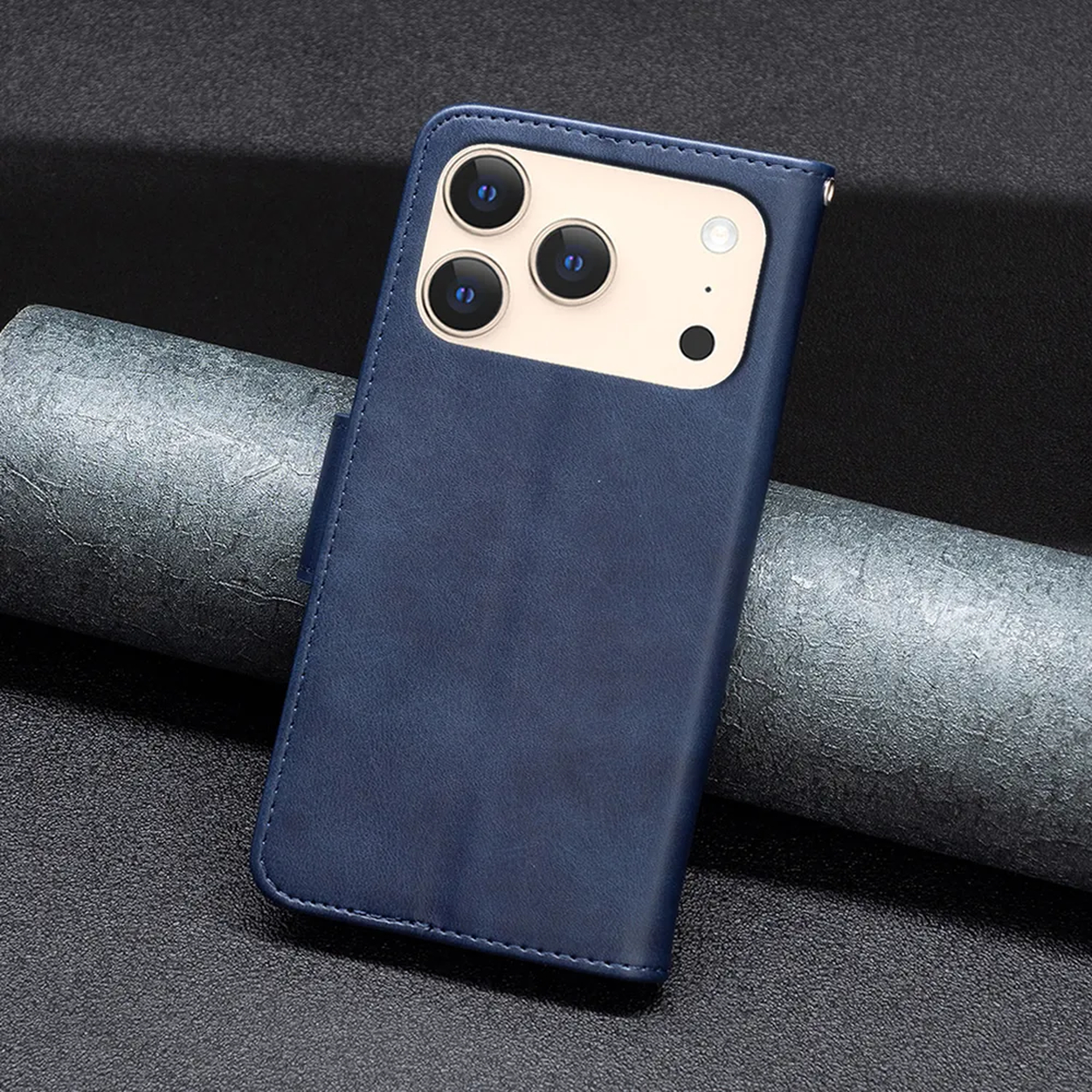Een blauwe telefoonhoes met drie cameralenzen en een flitser ligt op een getextureerd oppervlak, met een opgerolde grijze rol papier op de achtergrond.