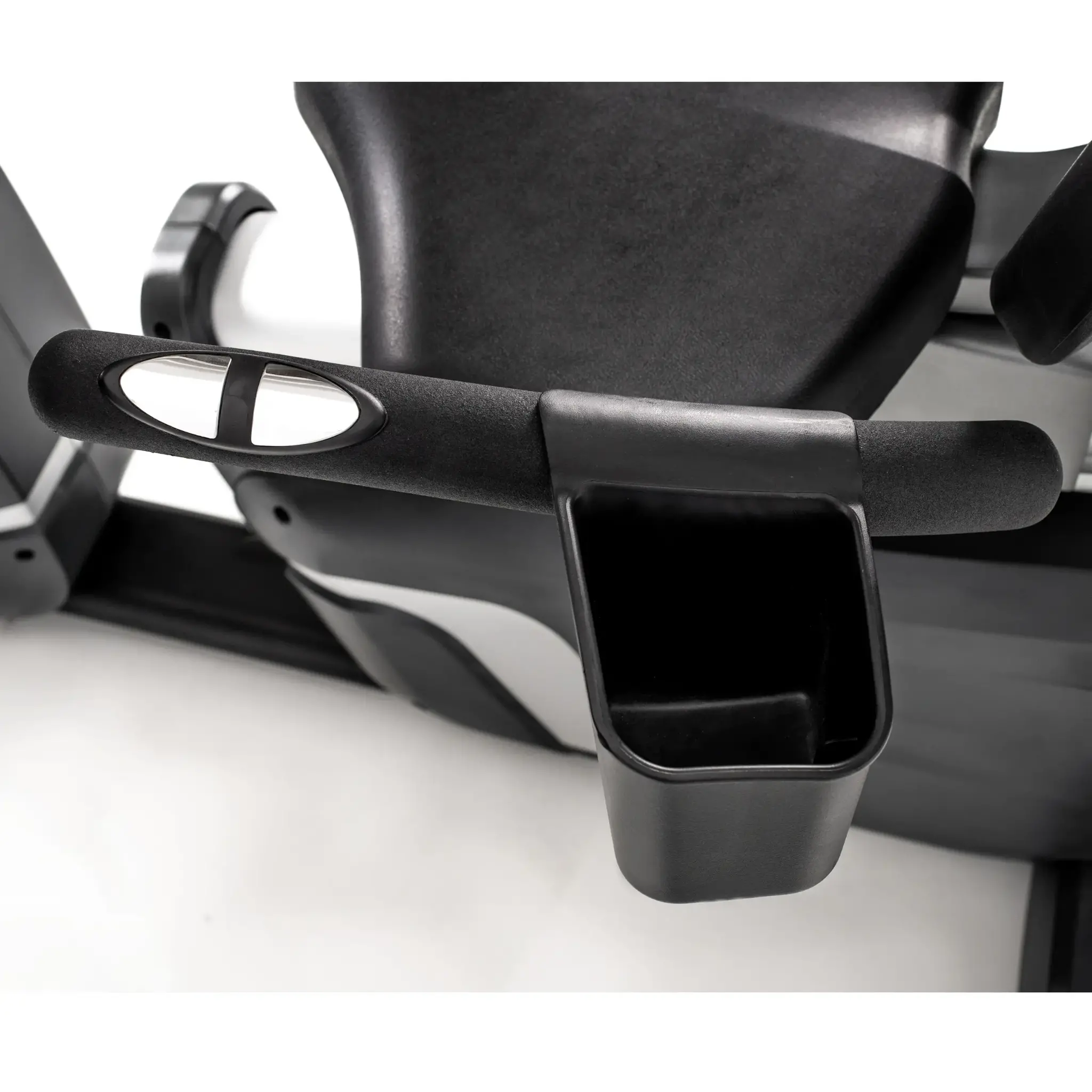 Close-up van de console van een zwarte hometrainer. Het heeft een bekerhouder en armleuning. De achtergrond is wit.