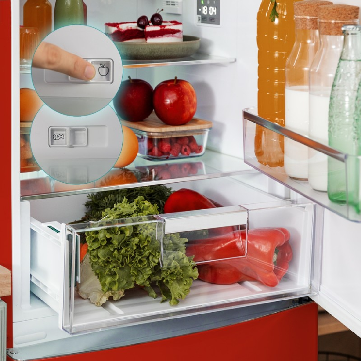 Interno del frigorifero con vari elementi: frutta, verdura, bevande e una fetta di torta. La porta è aperta. Due pulsanti sono visibili.