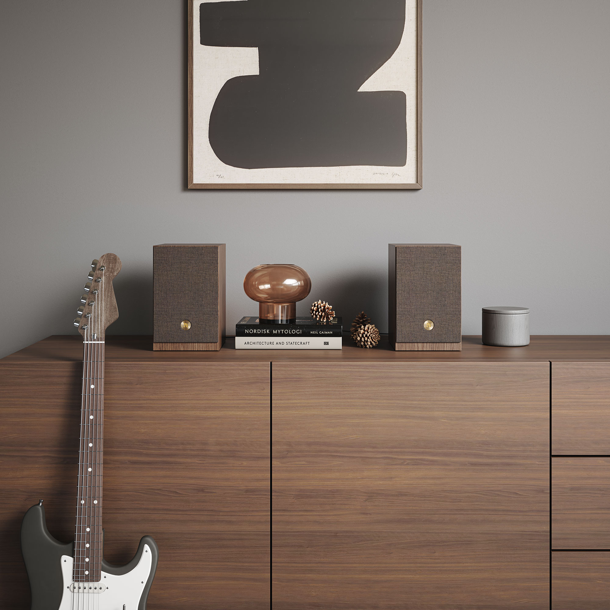 Ein Rauminterieur mit Gitarre, Lautsprechern, Büchern und Kunst. Eine dunkle Gitarre lehnt an einem Holzschrank.
