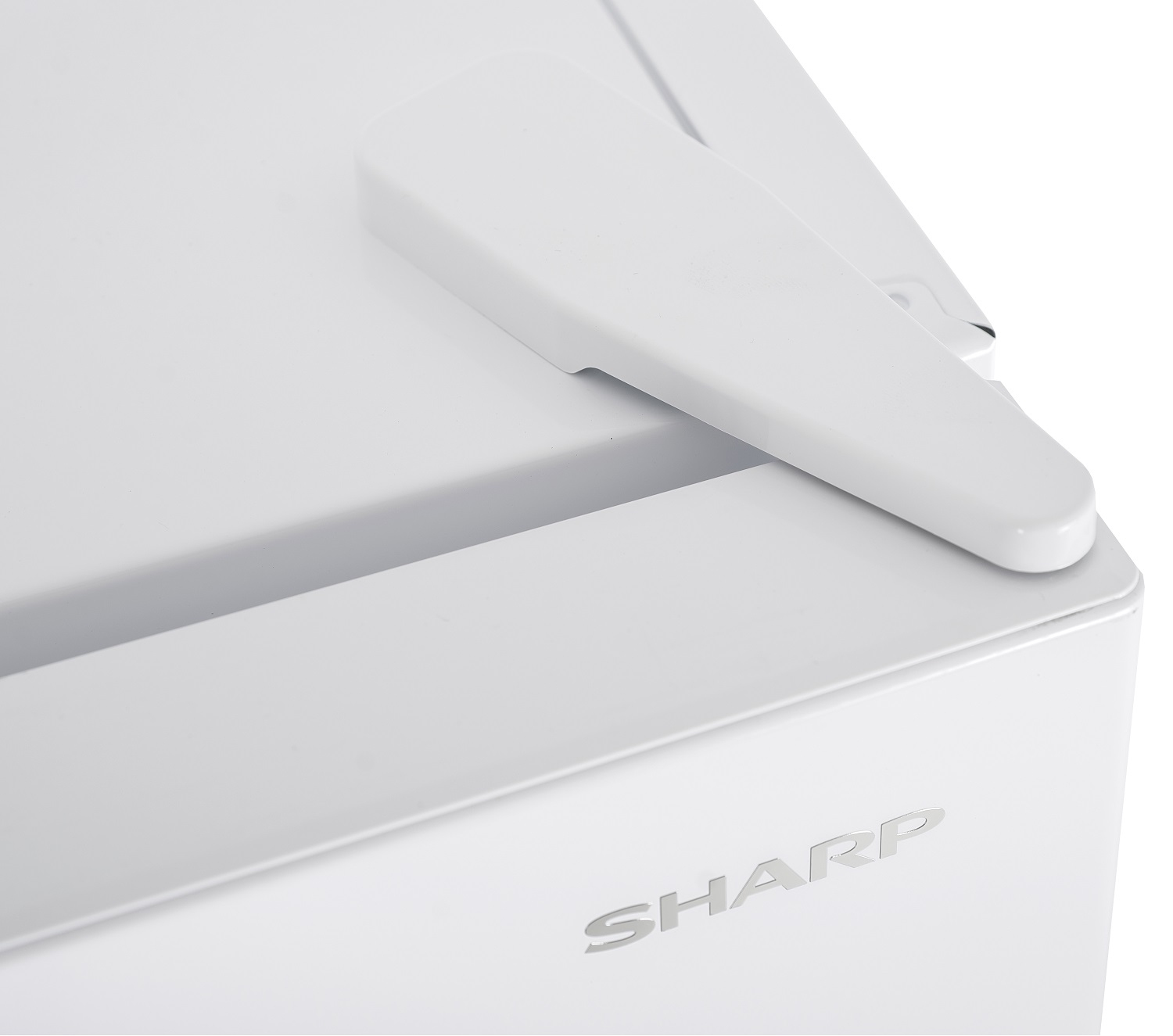 Primo piano di un elettrodomestico bianco con maniglia sporgente. La parola "SHARP" è visibile. La superficie sembra pulita e moderna.