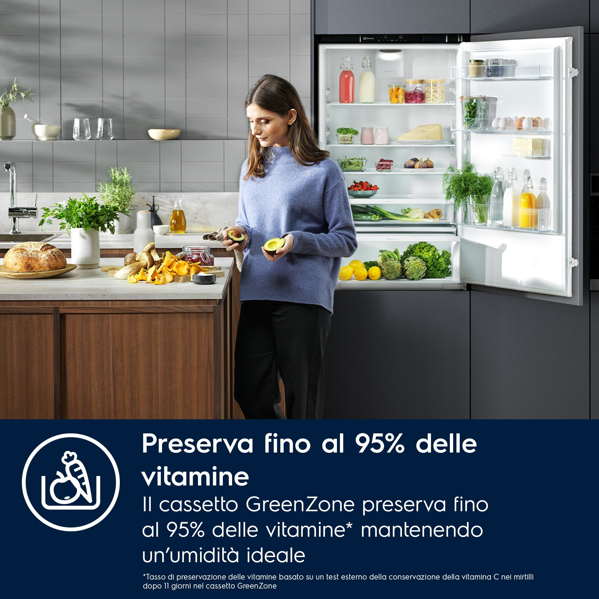 Donna in cucina con avocado, frigorifero aperto con cibo. Frutta, verdura e pane sul bancone. Testo sulla conservazione delle vitamine.