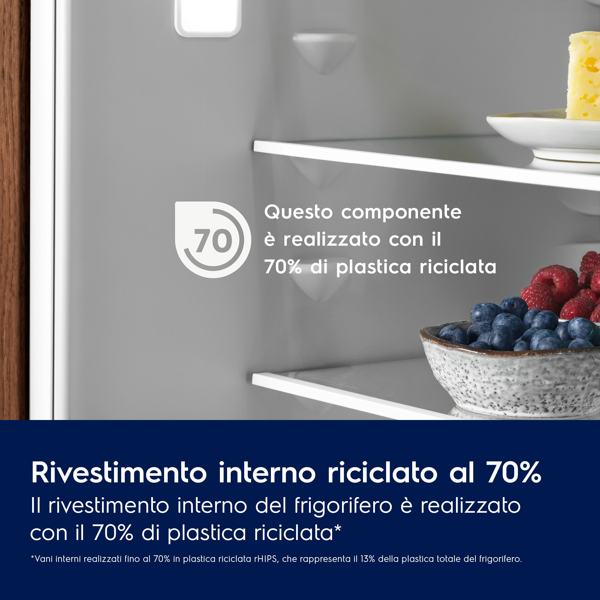 Dettaglio interno del frigorifero. Include testo sul 70% di plastica riciclata. Frutti di bosco e formaggio nel frigo.