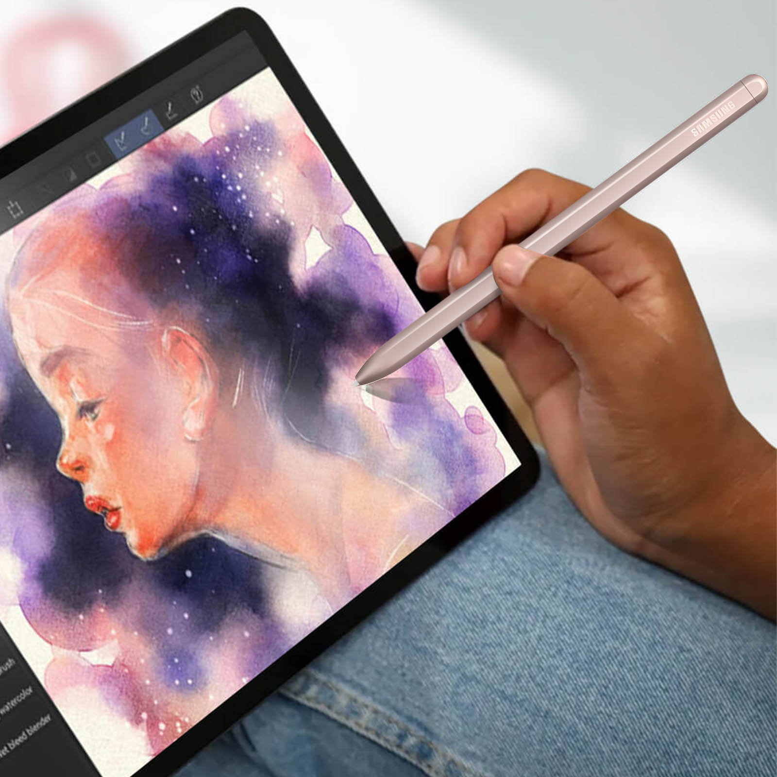 Eine Hand hält einen Stift über einem Tablet, auf dem ein Aquarellporträt zu sehen ist. Der Stift ist rosa und das Tablet ist schwarz.