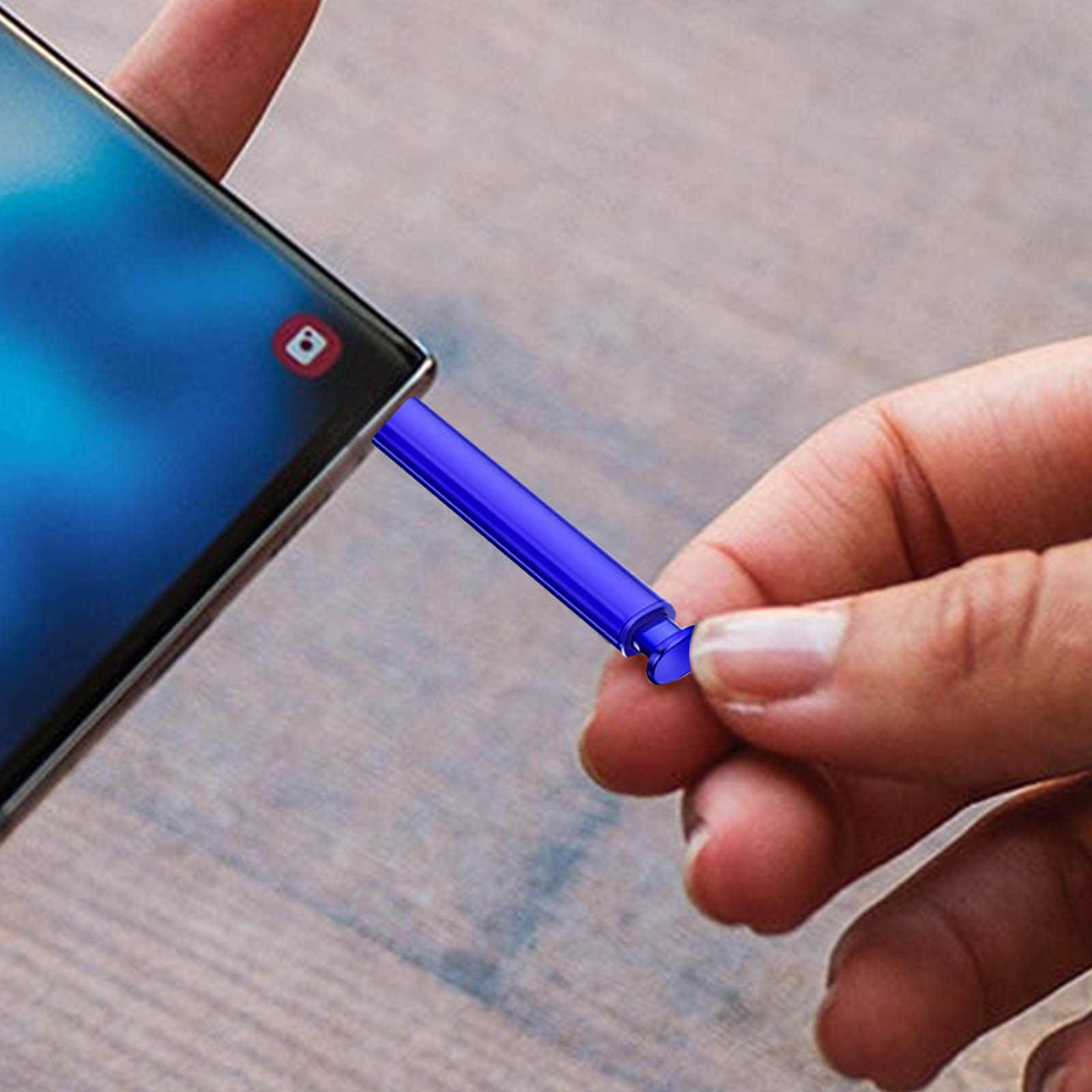 Una mano tiene uno stilo blu a lato di uno smartphone. Il telefono è nero e ha uno schermo blu.
