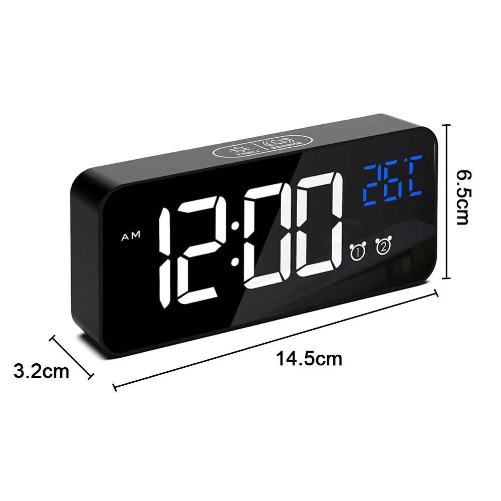 Schwarzer digitaler Wecker mit 12:00 AM und 26C. Maße sind 14,5 cm x 6,5 cm x 3,2 cm. Zwei Alarmsymbole sind sichtbar.