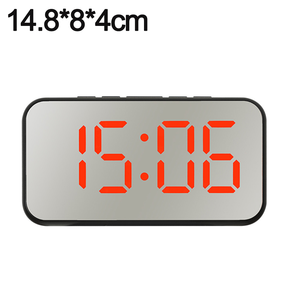 Eine Digitaluhr zeigt 15:06 in roten Ziffern auf einer reflektierenden Oberfläche an. Die Uhr ist rechteckig mit schwarzem Rahmen.