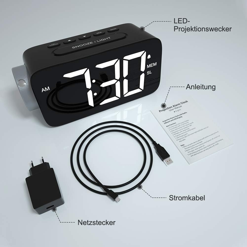 Ein schwarzer Wecker mit Digitalanzeige 7:30, mit Netzteil, Kabel und Bedienungsanleitung.