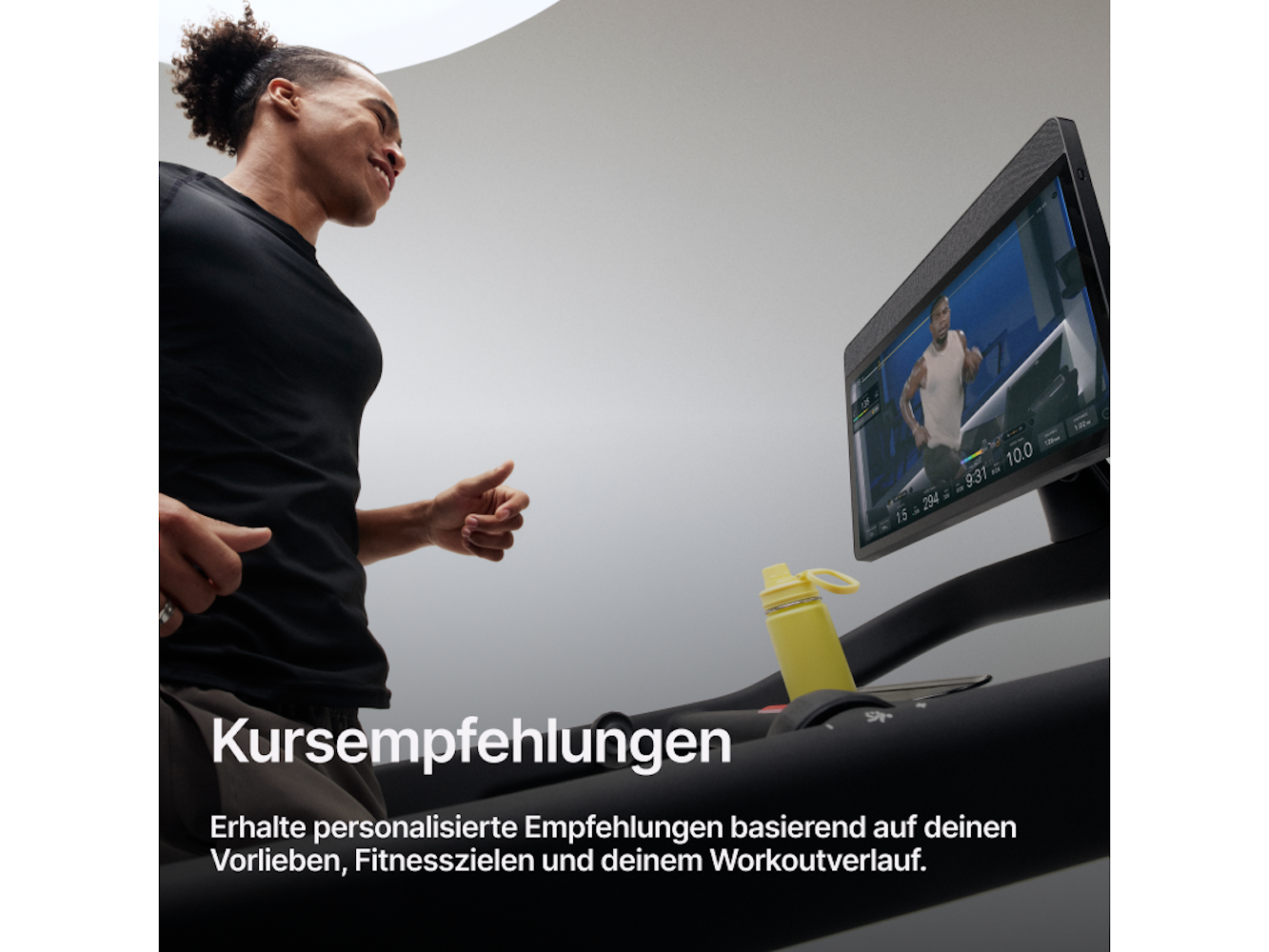Mann, der auf einem Laufband läuft und auf den Bildschirm schaut. Eine gelbe Wasserflasche steht daneben.