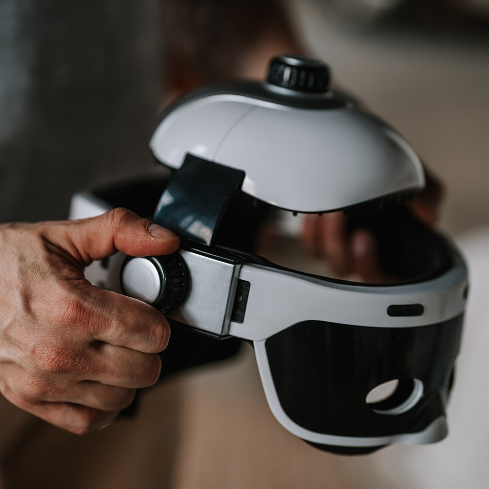 Eine Person hält ein VR-Headset. Das Headset ist weiß und schwarz. Die Hände der Person sind sichtbar.