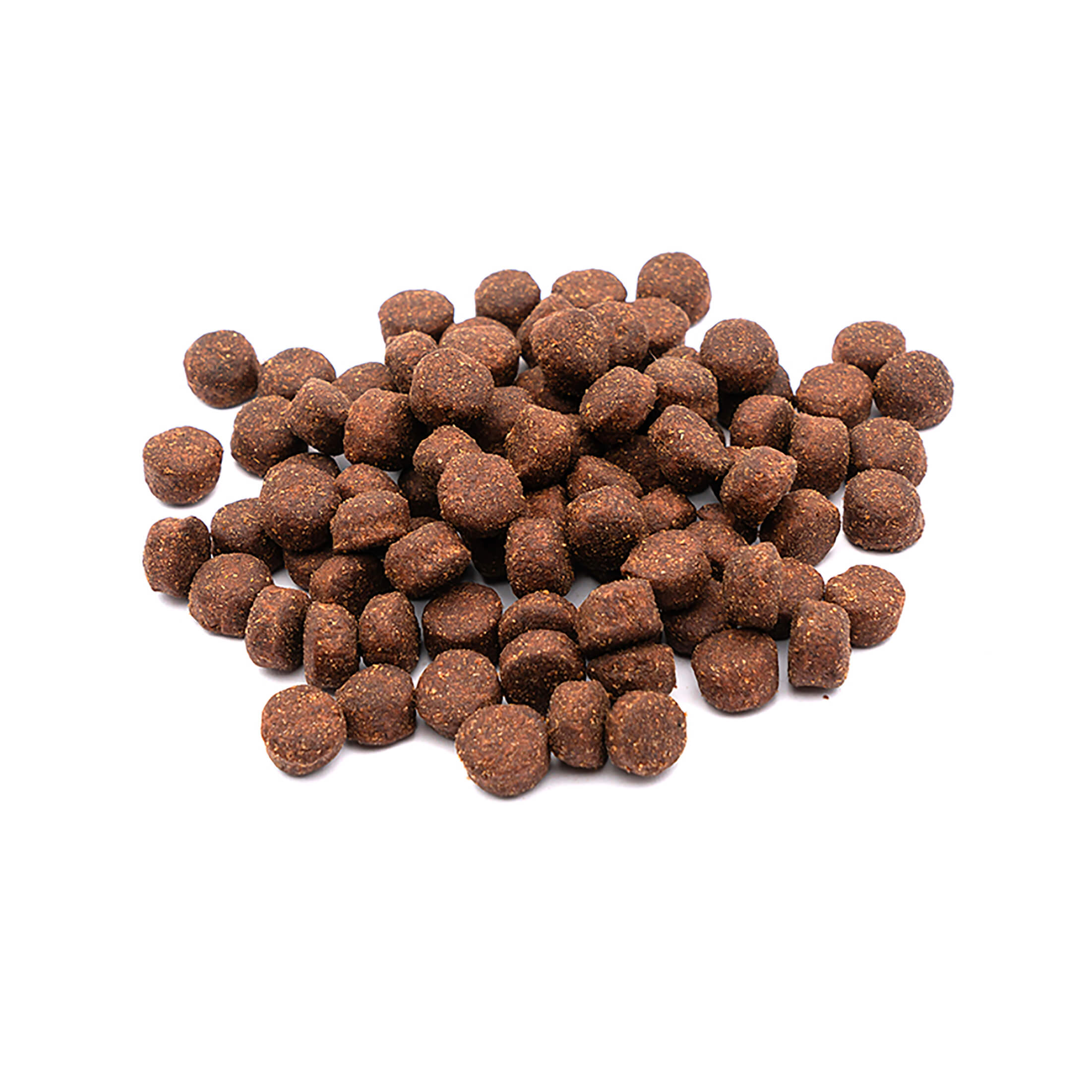 Un montón de pequeñas croquetas redondas de color marrón para mascotas sobre un fondo blanco. Las croquetas tienen textura.