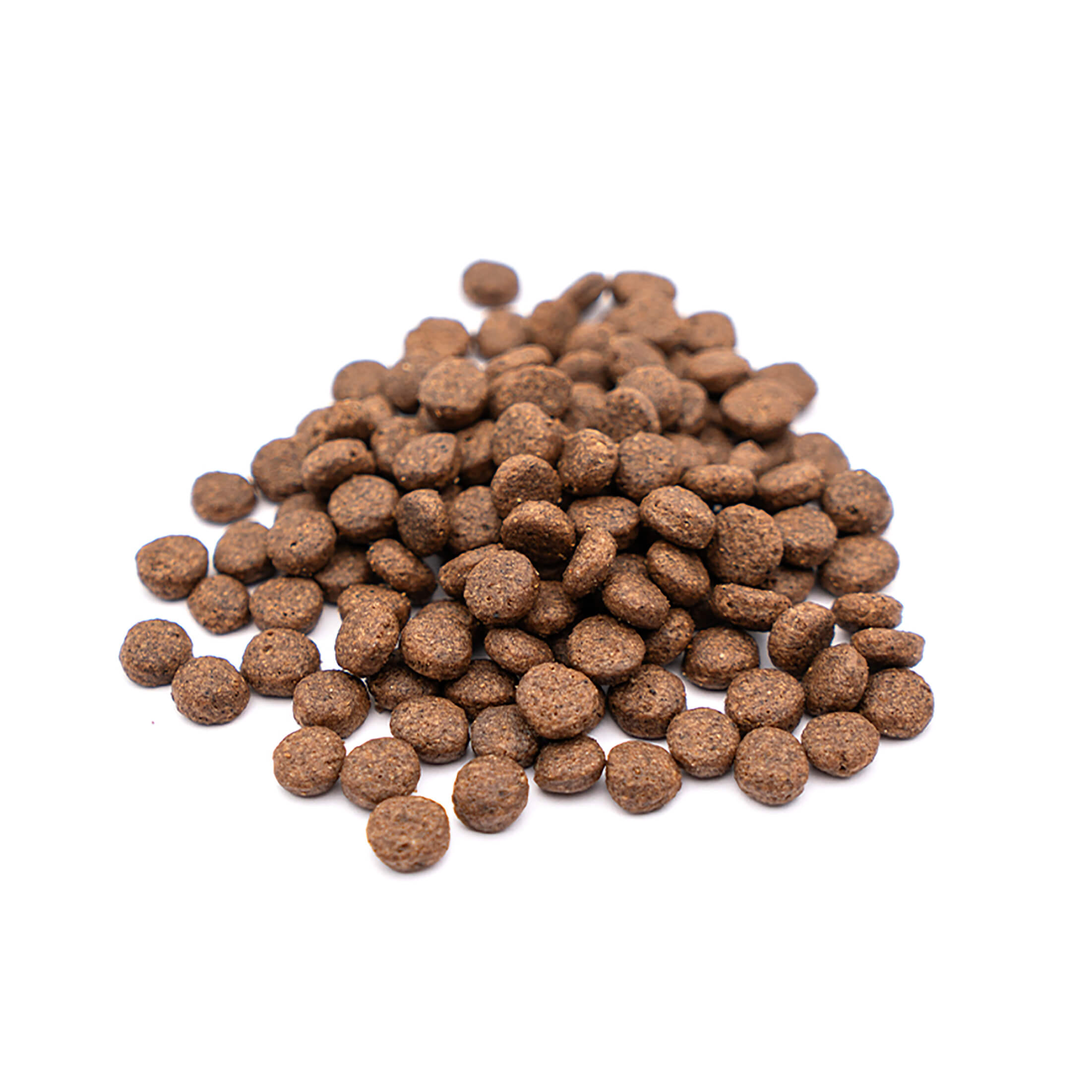 Un montón de croquetas redondas marrones para alimentos para mascotas sobre un fondo blanco. Las croquetas tienen forma circular texturizada.