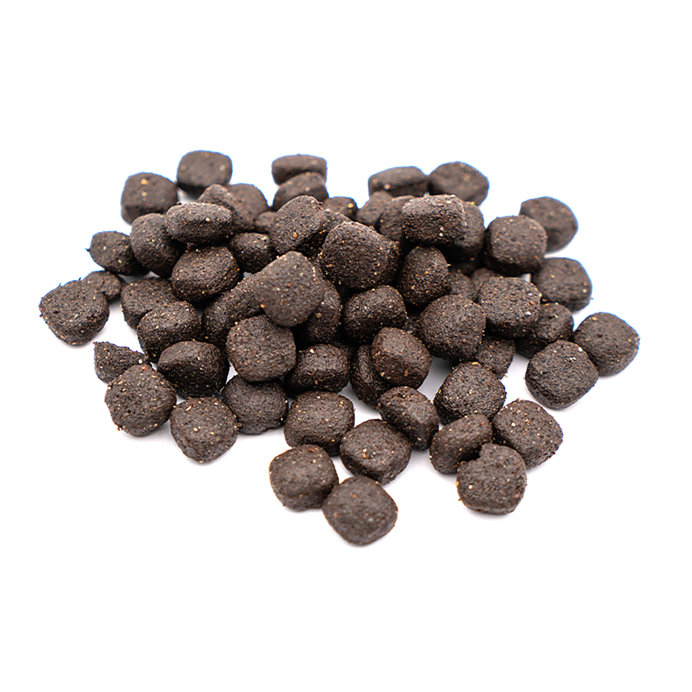 Primer plano de un montón de pequeñas piezas redondas de comida para mascotas de color marrón oscuro sobre un fondo blanco.