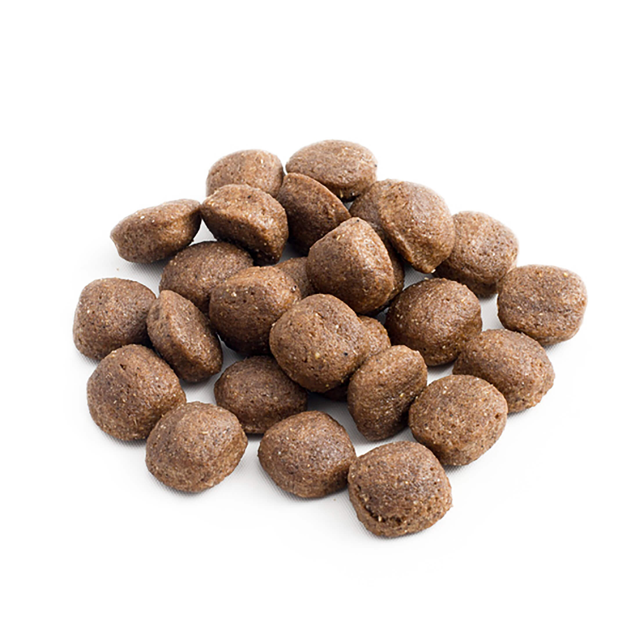 Montón de croquetas de alimento para mascotas marrones y redondas sobre fondo blanco. La croqueta es texturizada y ligeramente áspera.