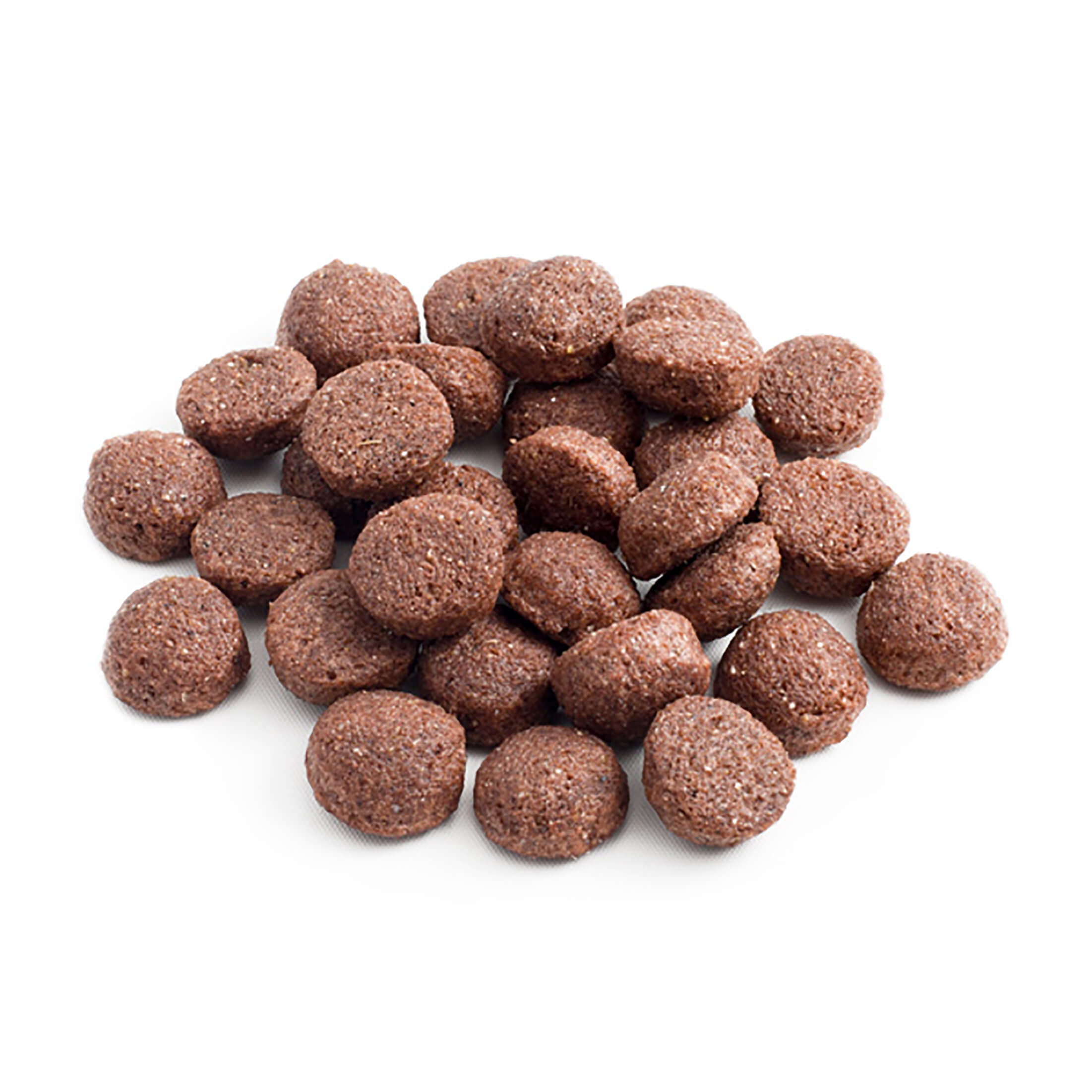 Un montón de croquetas redondas marrones para comida de mascotas sobre un fondo blanco. Las croquetas tienen superficie texturizada y motas blancas.