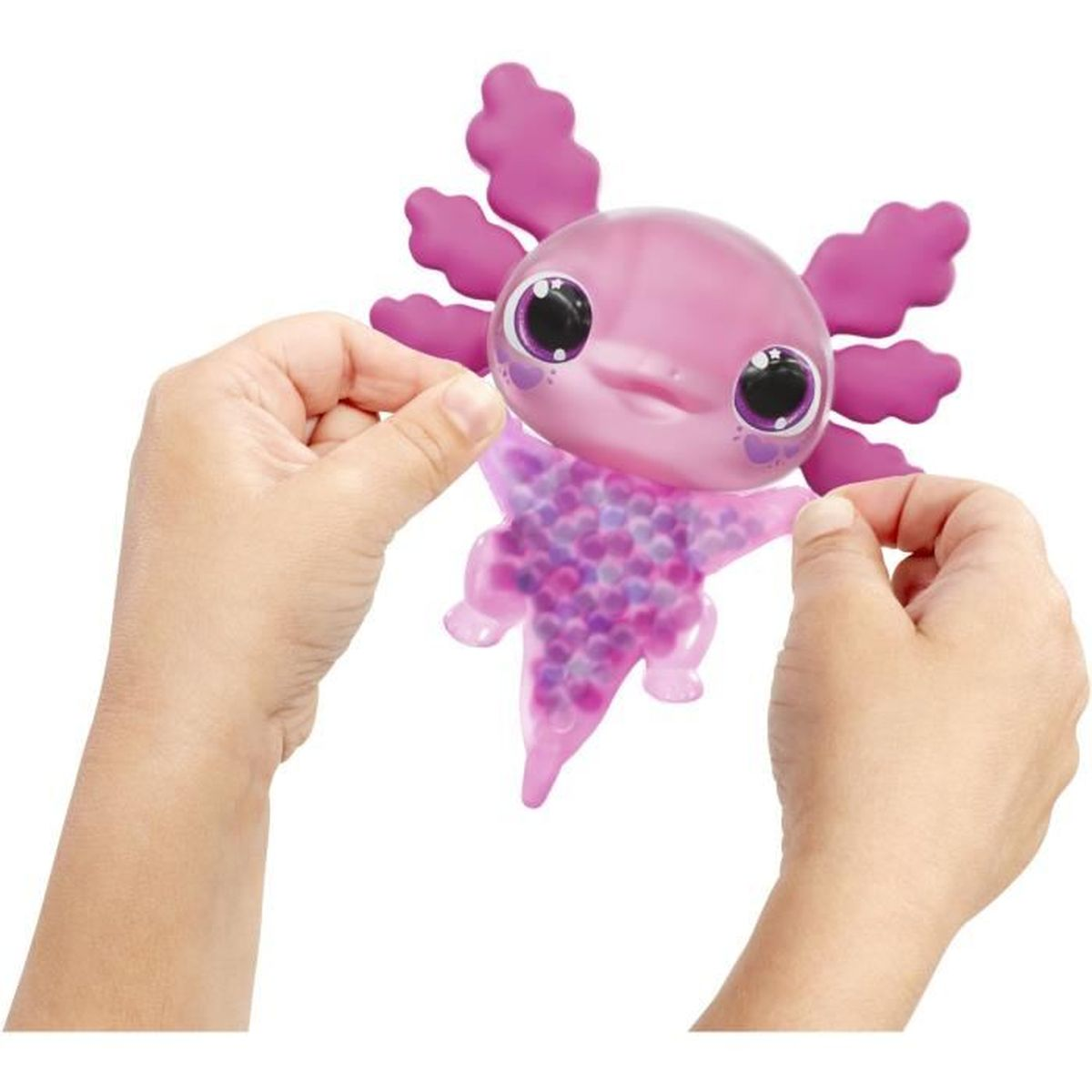 Mains tenant un jouet axolotl rose. Le jouet a une tête bulbeuse, de grands yeux et un corps en forme d'étoile rempli de perles violettes.