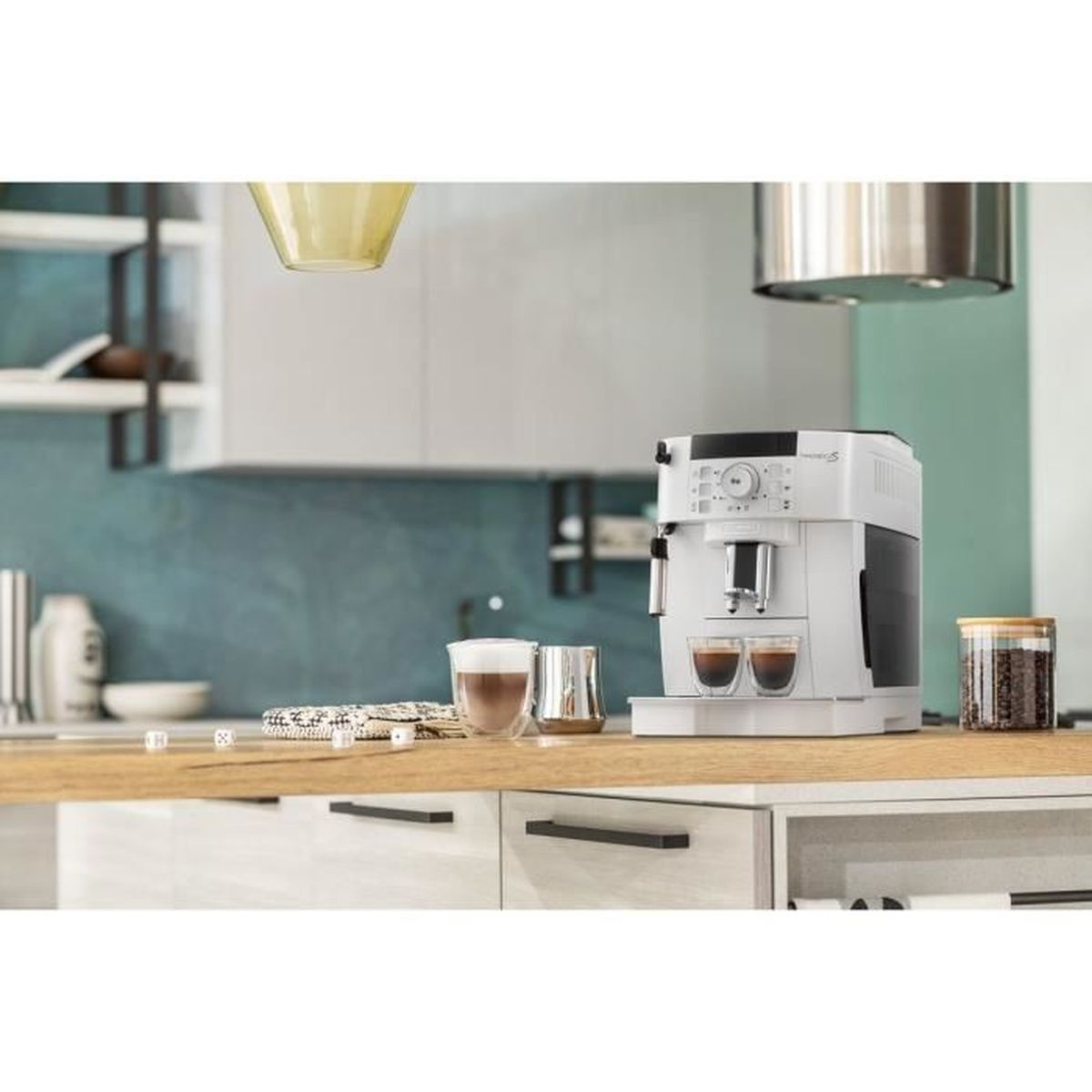Una macchina da caffè bianca è su un bancone di legno con due bicchieri di caffè. Altri oggetti sono visibili sullo sfondo.