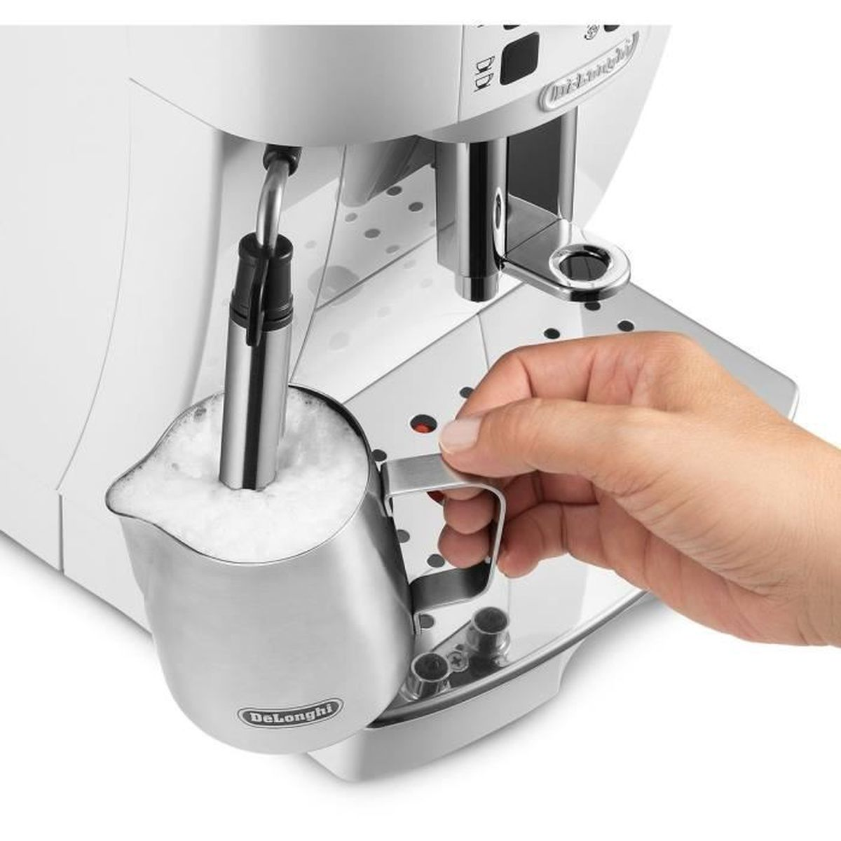 Una mano tiene un bricco in acciaio inox con latte montato, accanto a una macchina da caffè bianca. La macchina ha un beccuccio vapore.