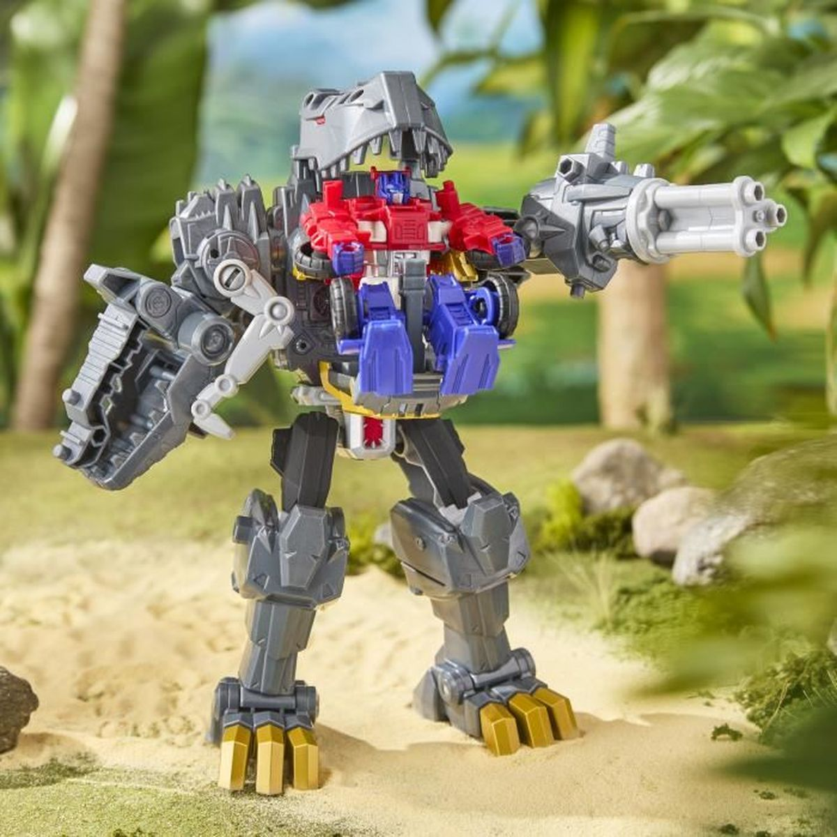 Un giocattolo di dinosauro robot grigio con un robot rosso e blu al centro, su uno sfondo verde e sabbioso.
