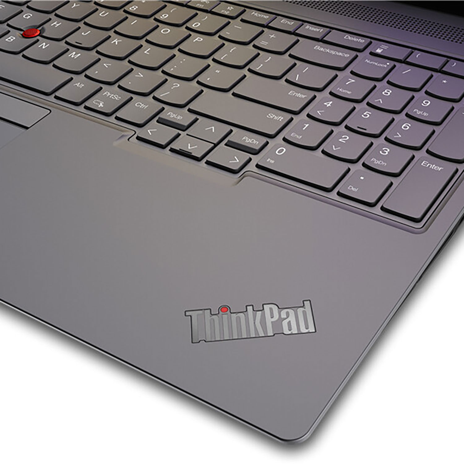 Klawiatura laptopa z klawiszami i srebrnym logo ThinkPad na szarej powierzchni. Czerwona kropka nad literą 'i'.