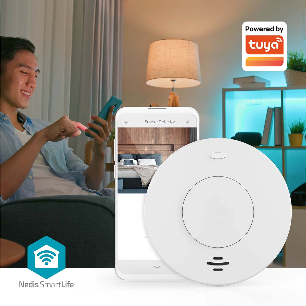 Ein Mann benutzt ein Smartphone, davor ein Rauchmelder, im Hintergrund eine Lampe und ein Regal mit Pflanzen.