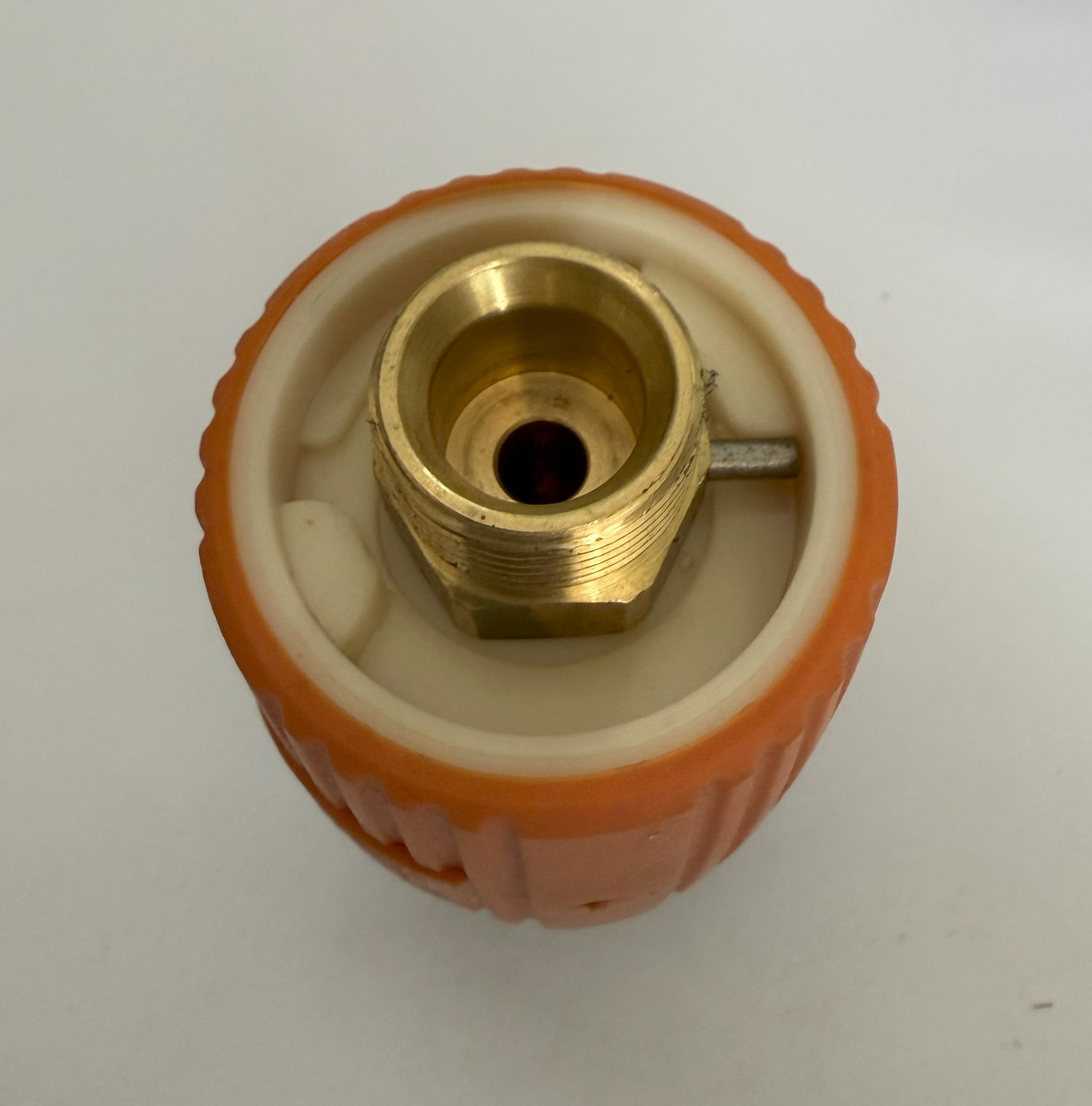 Draufsicht auf ein Messingfitting in orangefarbenem und weißem Kunststoff. Der Hintergrund ist schlicht weiß.