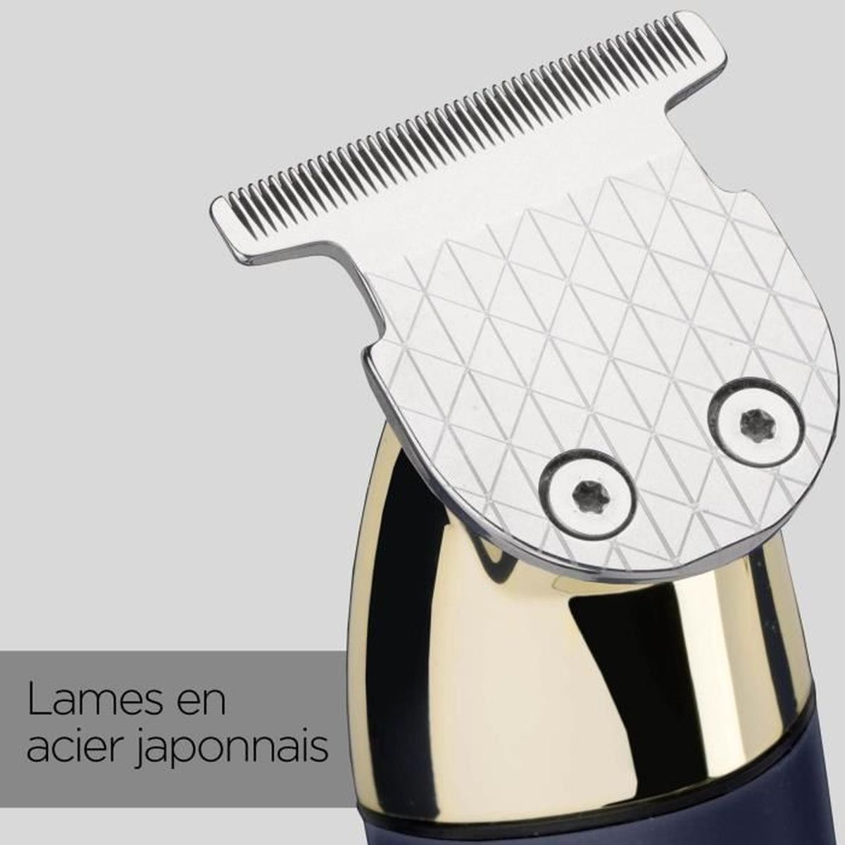 Close-up of a silver and gold hair clipper. The blade is silver with a geometric pattern. The base is gold and black.