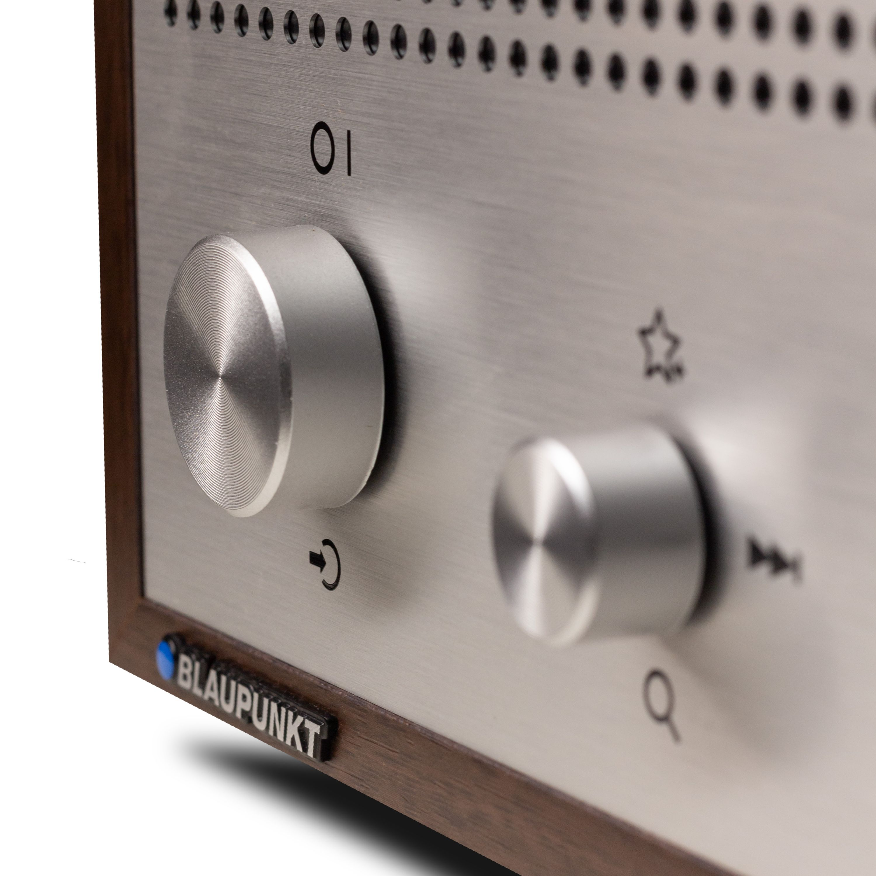 Nahaufnahme eines Radiobedienfelds mit Knöpfen, Tasten und dem Blaupunkt-Logo. Silber- und Brauntöne sind vorhanden.