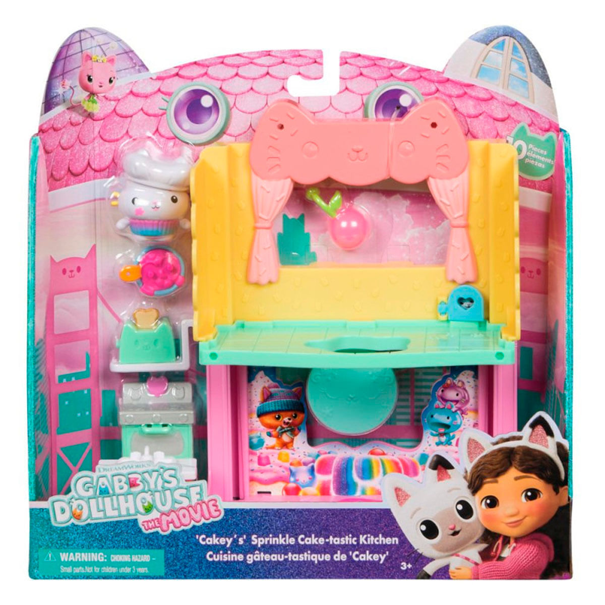 Ein Gabby's Dollhouse Spielzeugset. Es zeigt eine Spielküche mit Spielzeugfiguren, ein rosa-gelbes Design und die Charaktere Gabby und Cakey.