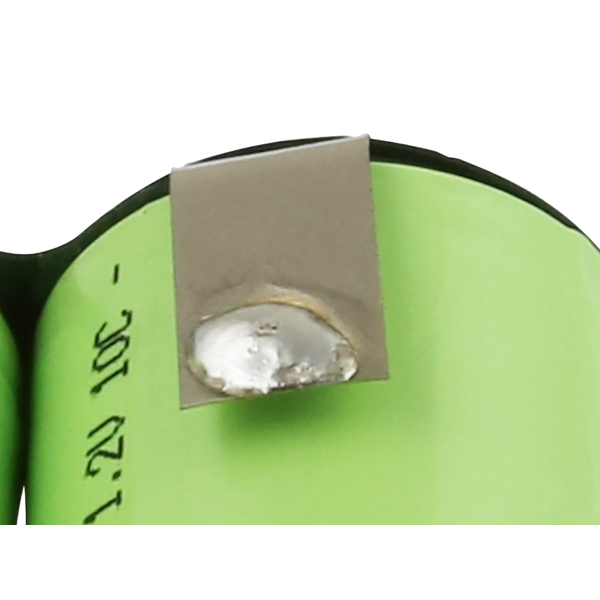 Primo piano di una batteria cilindrica verde con linguetta metallica. La linguetta è fissata con saldatura color argento.