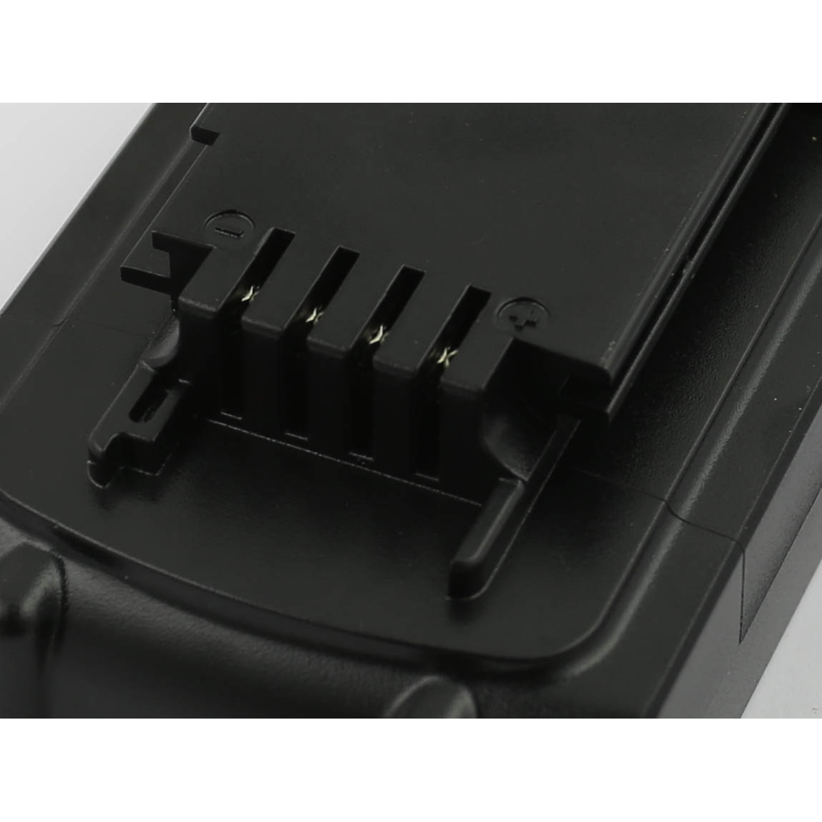 Primo piano di un oggetto rettangolare nero, forse un pacco batteria. Ha diversi punti di contatto metallici e una superficie strutturata.