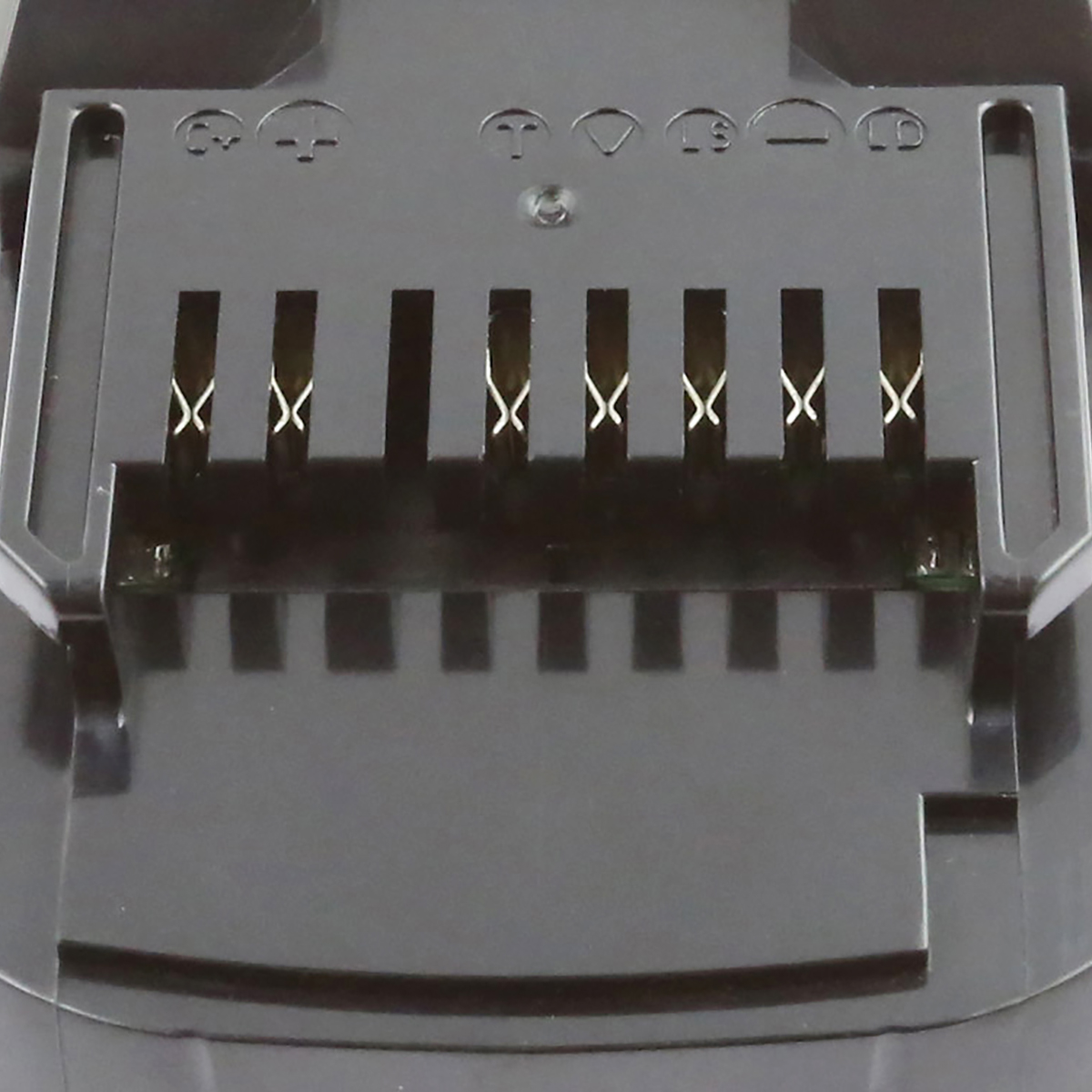 Primo piano di un connettore batteria nero. Ha diversi pin metallici e più simboli. Lo sfondo è scuro.