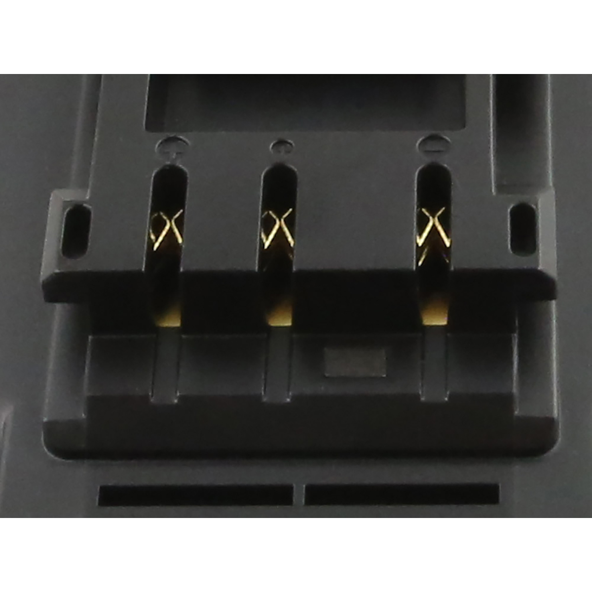 Primo piano di un componente elettronico nero con tre connettori color oro. Il componente è rettangolare con fessure.