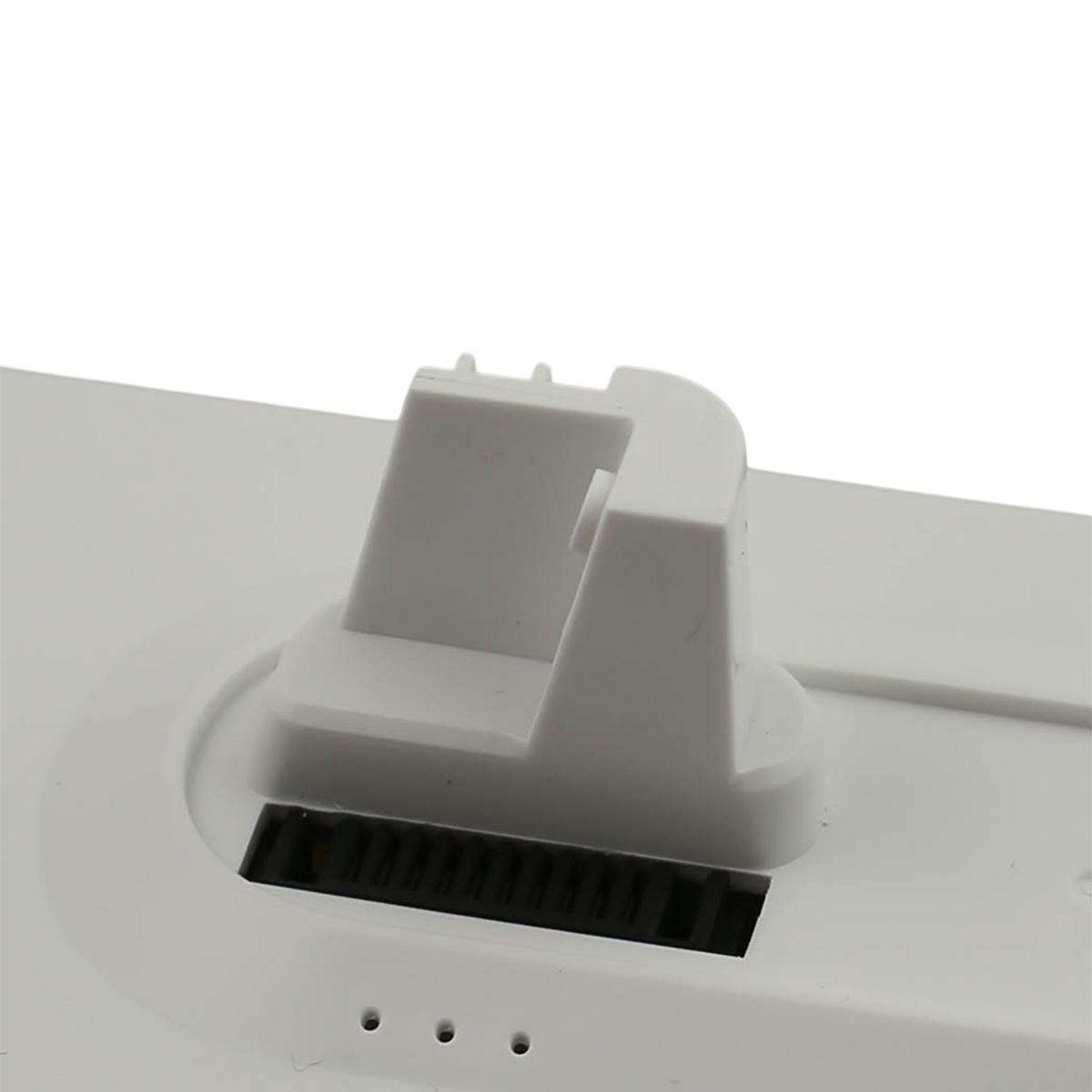 Primo piano di un dispositivo di plastica bianca. Ha una base rettangolare con una fessura nera e una struttura angolata rialzata.