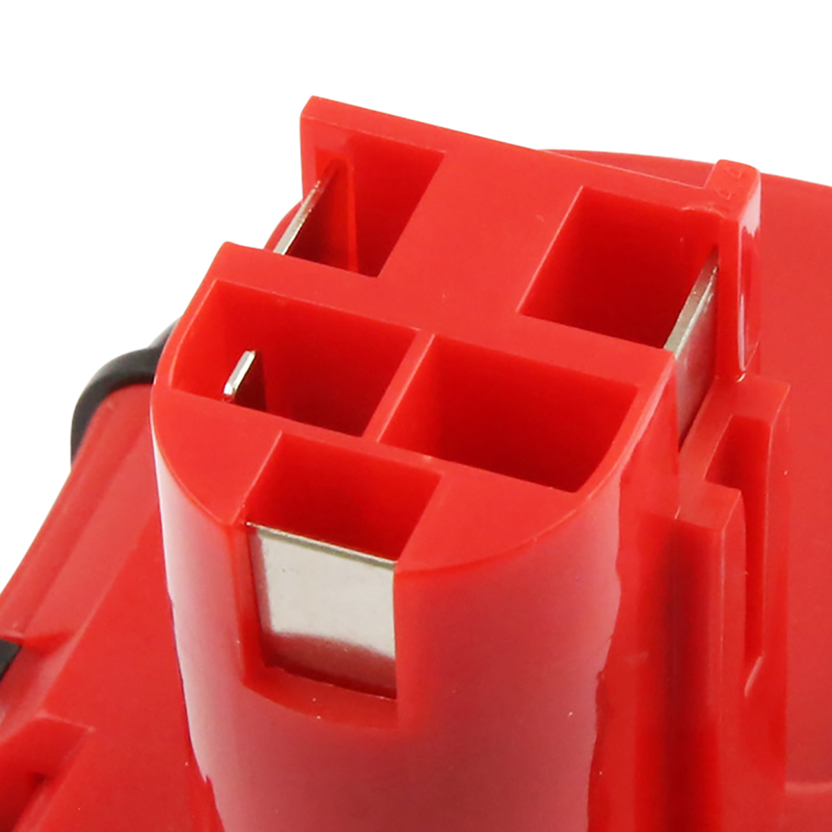 Primo piano di un componente in plastica rossa con connettori metallici. Il componente ha una forma rettangolare con diverse aperture quadrate.