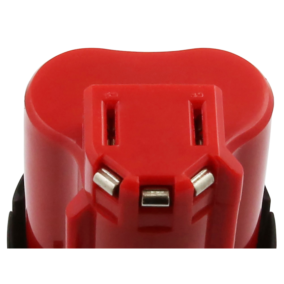 Primo piano di una batteria rossa per utensili elettrici. Ha contatti metallici e fessure. Sfondo bianco e nero.