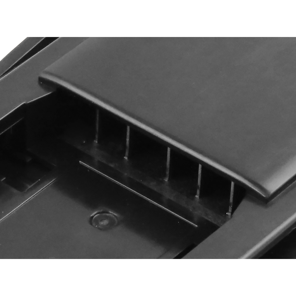 Primo piano di un componente in plastica nera. Una parte superiore rettangolare con sottili barre verticali sottostanti. La superficie è riflettente.