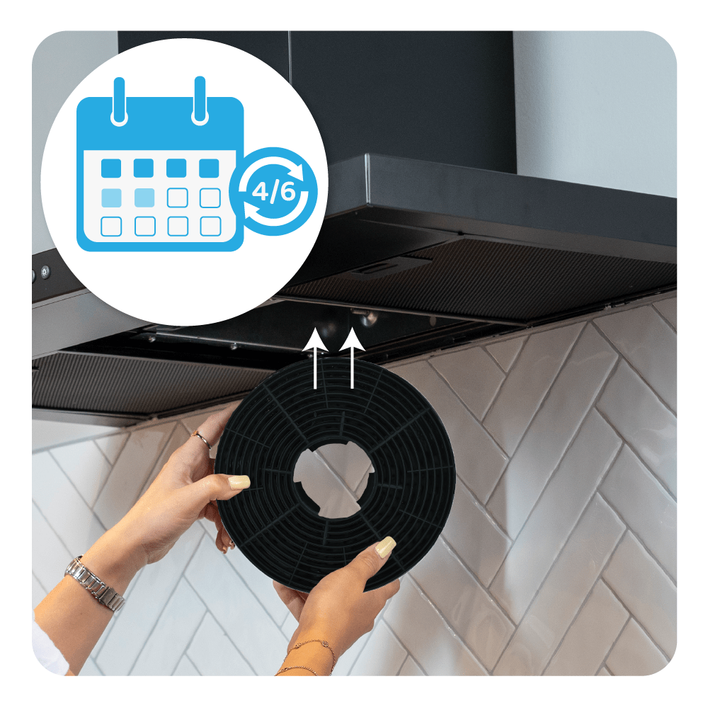 Dłonie trzymają czarny filtr z ikoną kalendarza i strzałkami w górę. Filtr jest w okapie kuchennym.